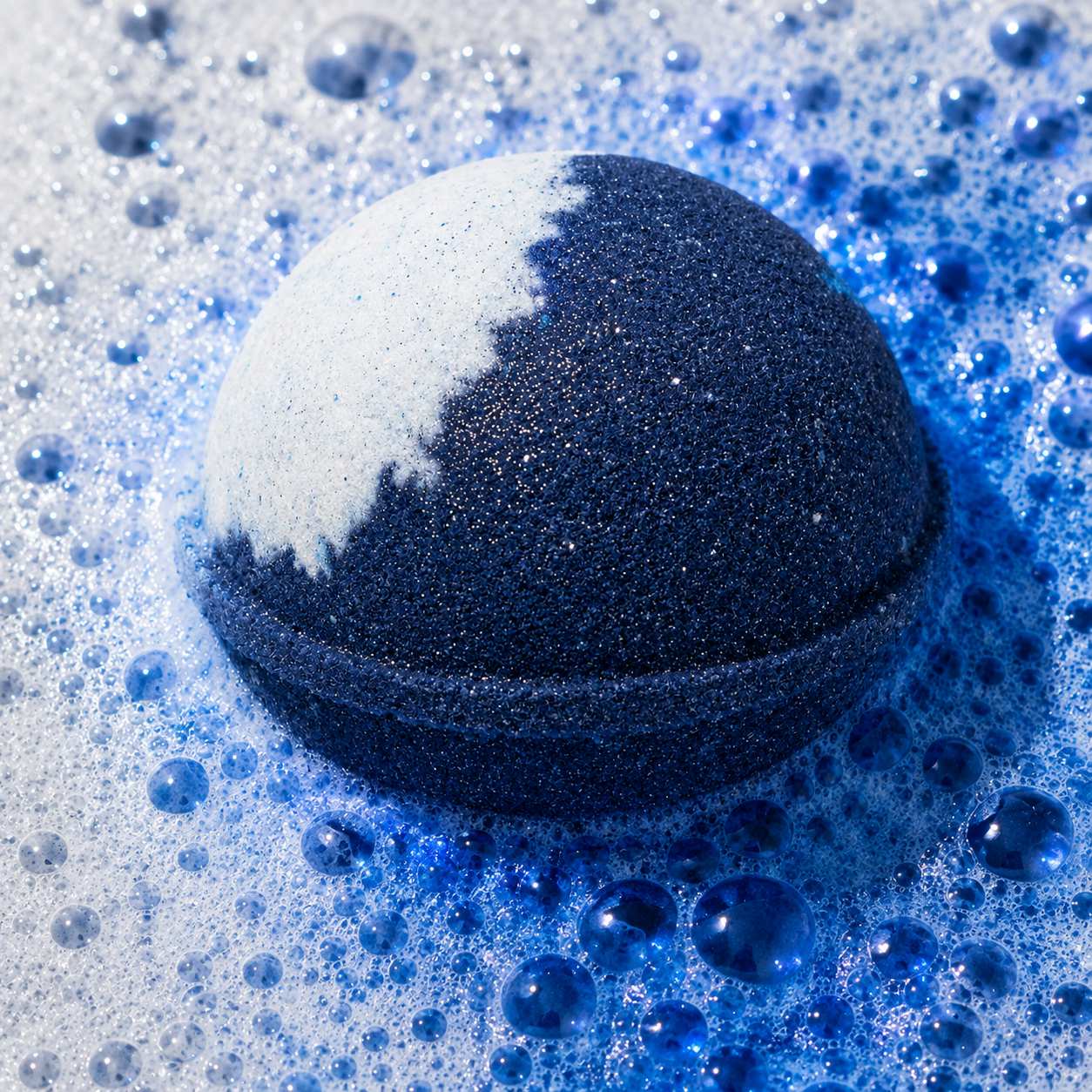 Moonlight Sandalwood Vanilla Bath Bomb fizzing in water by Bath Box