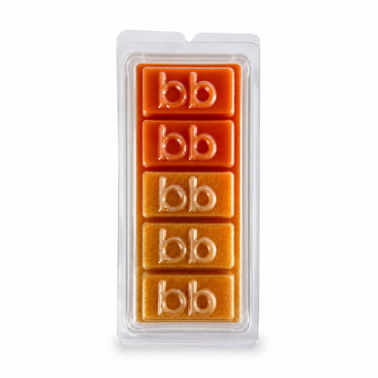 Christmas Glow orange pineapple soy wax melts in a clear clamshell pack, burnt orange to amber cubes embossed with the Bath Box logo