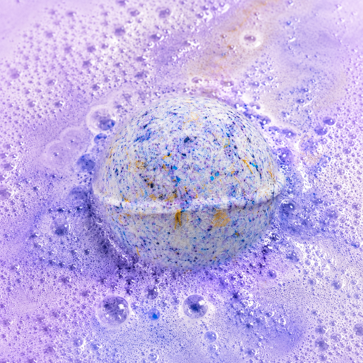 Bedtime Brew Black Tea & Lychee Bath Bomb fizzing in water by Bath Box