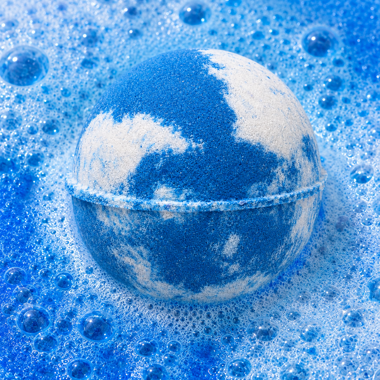 Soft Clouds Oatmeal Milk & Honey Bath Bomb fizzing in water by Bath Box